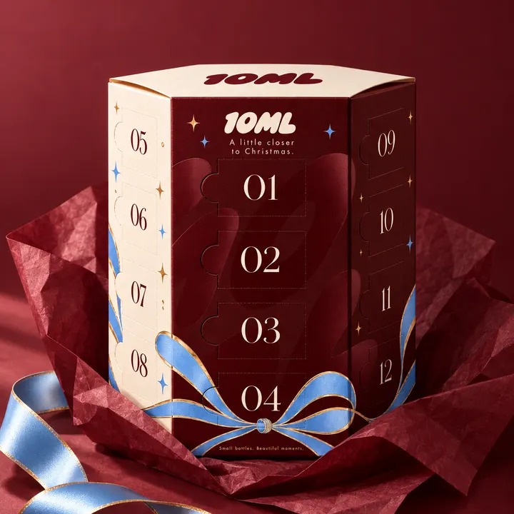 The calendar unwrapped from red tissue paper, its ribbon loose beside it
